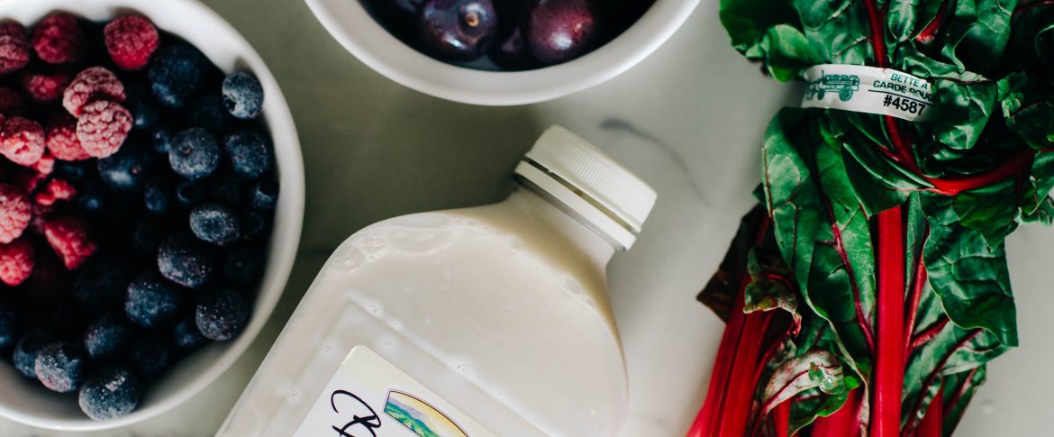 Ingredients to make a berry and greens vegan smoothie recipe using bolthouse diary free milk